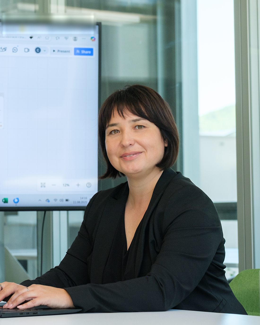 Carmen Breiter arbeitet am Laptop vor einem großen Bildschirm